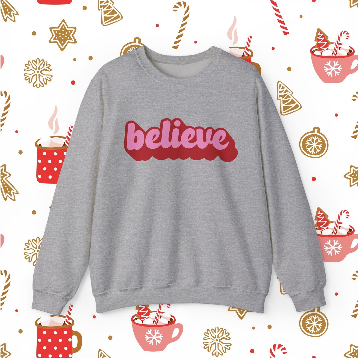 Gray sweatshirt with 'believe' in red on a festive background with hot cocoa and candy cane patterns.