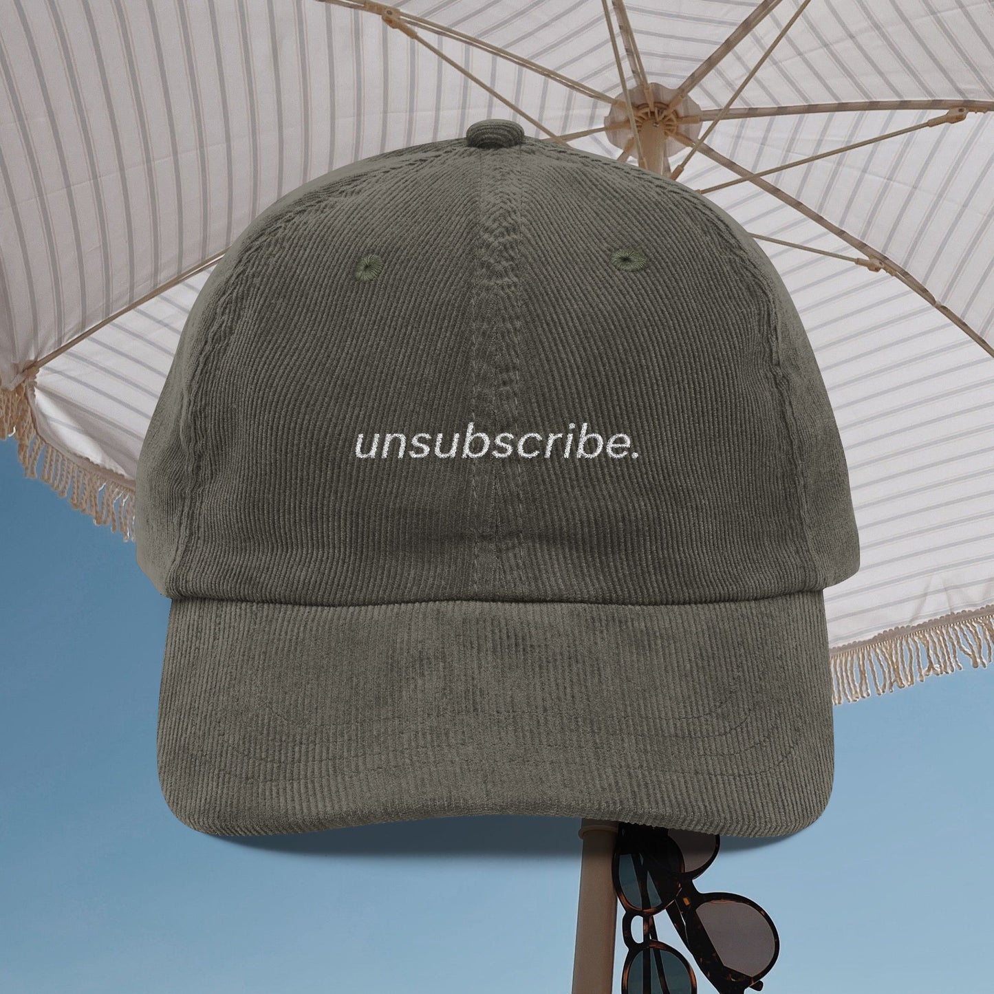 Gray cap with 'unsubscribe.' text under a white umbrella